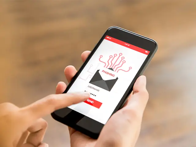 Illustrative photo: a phone showing a phishing email warning.
